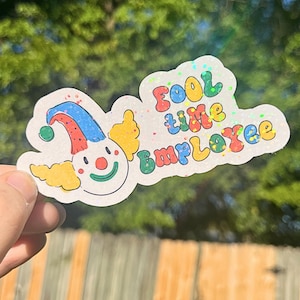 May include: A white sticker with a colorful cartoon clown and the text "Fool time Employee".