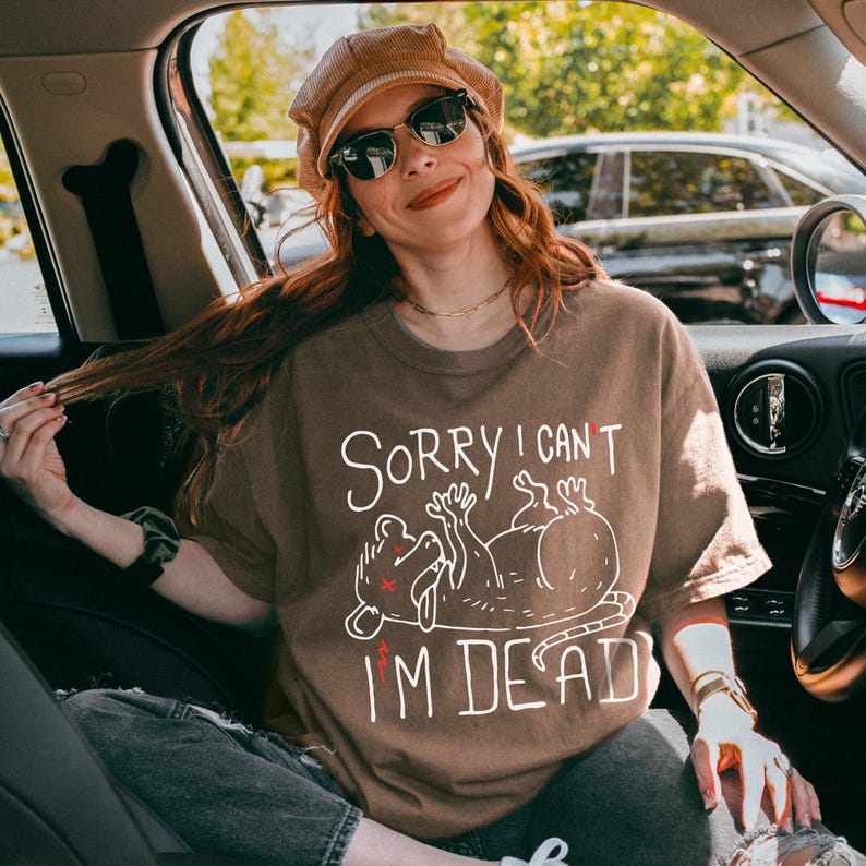 Text: "Sorry I Can't I'm Dead" Possum Sketch, Tongue Out with X Eyes Brown Shirt, White Text and Outline, Funny Meme Tee, Introverted, Anxiety Opossum, Unhinged Tees, Weird Stuff, Weirdcore, Trash, Emotional DumpsterFire