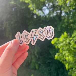 May include: A holographic sticker with the text "LCSW" in a bold, stylized font. The sticker features a lightning bolt design.