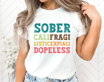 May include: White t-shirt with the text "SOBER CALIFRAGI LISTICEXPIALI DOPELESS" in colorful, vintage-style lettering.
