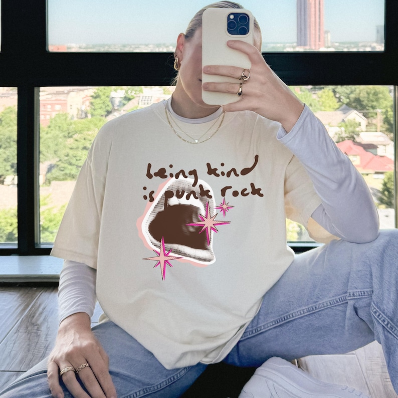 Comfort Colors 1717 Shirt
Color: Ivory (cream, off white)
Graphic: open screaming mouth in a retro halftone print, surrounded by pink stars and starbursts, with the handwritten phrase “Being Kind is Punk Rock” above in brown lettering
Title: Being Kind Is Punk Rock Shirt, Retro Streetwear Tee, Oversized Y2K, Soft Grunge, Kindness Quote, Alt Clothing, Comfort Colors Unisex