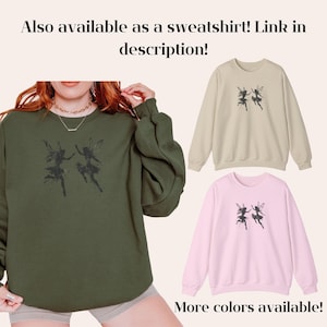 May include: A green sweatshirt with a graphic of two fairies dancing. The text "Also available as a sweatshirt! Link in description!" is at the top of the image. The text "More colors available!" is at the bottom of the image.