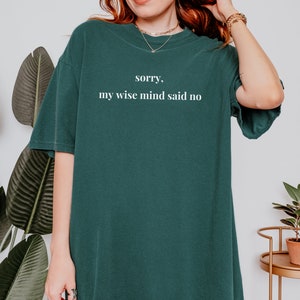 May include: A dark green t-shirt with the text "sorry, my wise mind said no" printed in white.
