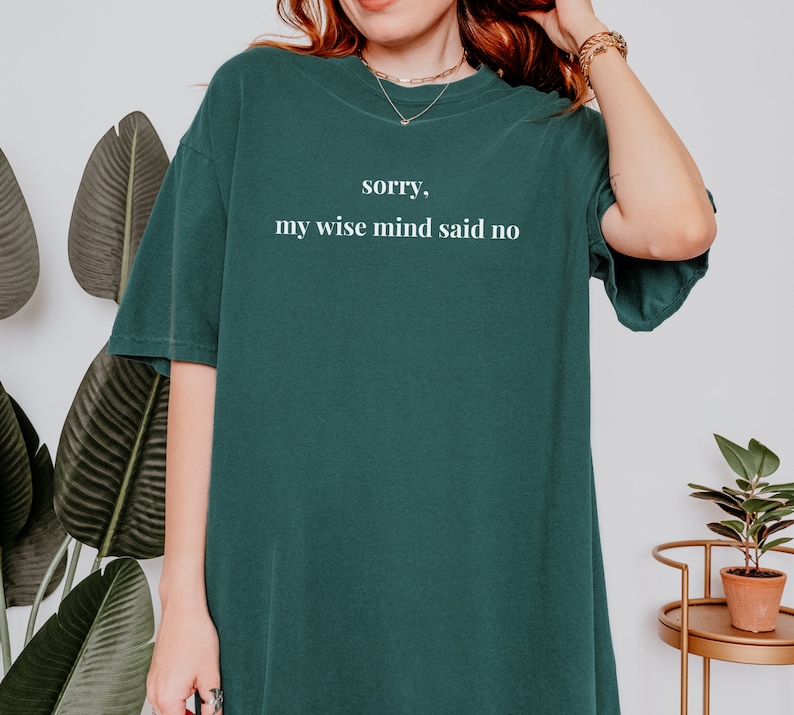 May include: A dark green t-shirt with the text "sorry, my wise mind said no" printed in white.