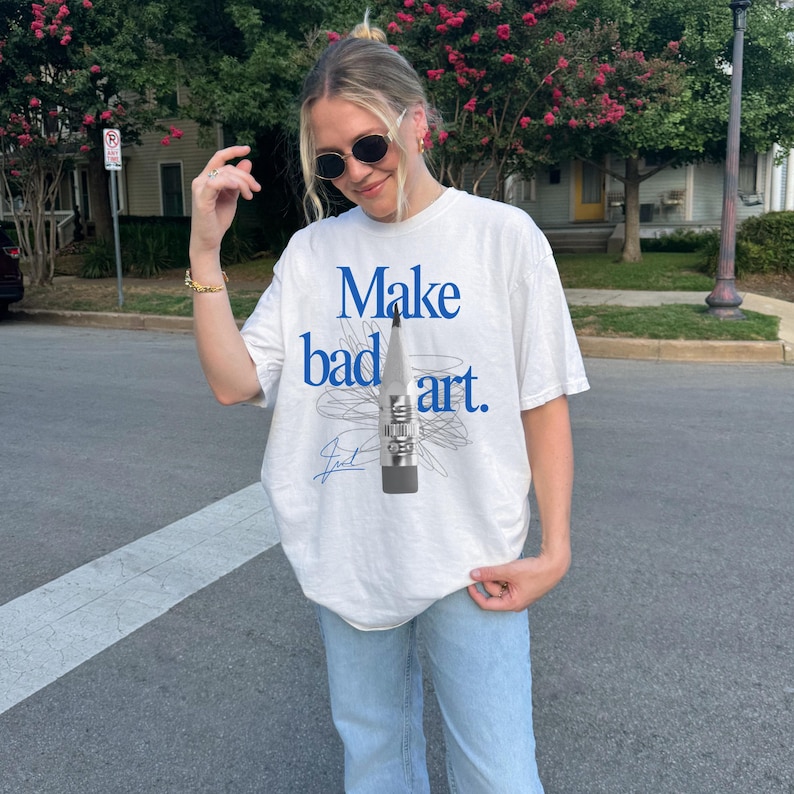 Comfort Colors 1717 Shirt
Color: White
Graphic: Bold blue text that reads ‘Make bad art' behind a pencil graphic, with scribble doodle lines in gray and a signature-style accent in bottom corner
keywords: art hoe aesthetic, art teacher gift, urban grunge outfit, feminist, activist tee, retro baddie shirt, gift for crafter, artivism, activism, gift for writer, poet, early 2000s clothing, cool girl, it girl, minimalist typography, cute creative, alternative fashion, art student
