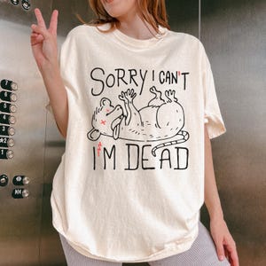 Text: "Sorry I Can't I'm Dead" Possum Sketch, Tongue Out with X Eyes Offwhite Shirt, Black Text and Outline, Opossum Meme, Anxiety, Funny Mental Health, Oversized Music Festival Tshirt Ironic Shirts Gift Ideas