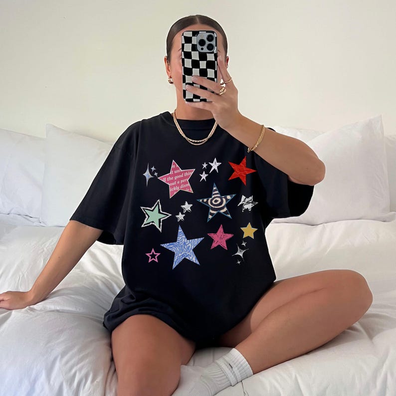 Comfort Colors 1717 T-Shirt
Color: Black
Graphic: Colorful collage-style star graphic featuring various hand-drawn and patterned stars scattered across the chest. The stars include a mix of animal prints, stripes, solid colors, and textures, with some metallic and doodle-like accents.