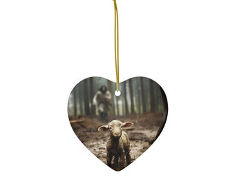 Può includere: Un ornamento in ceramica a forma di cuore con un agnello bianco in piedi in una radura boscosa fangosa. Una figura sullo sfondo cammina verso l'agnello.