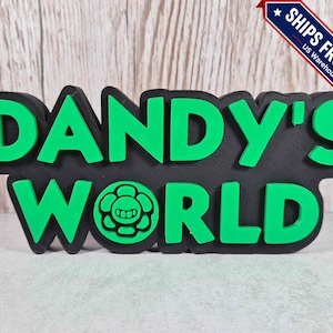 May include: A three-dimensional sign featuring the text DANDY'S WORLD in bright green raised lettering against a black background. The letter O in WORLD is replaced by a circular icon depicting a stylized flower with a smiling face in the center.