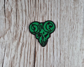 Può includere: Plettro per chitarra verde con un design a forma di teschio e corna.