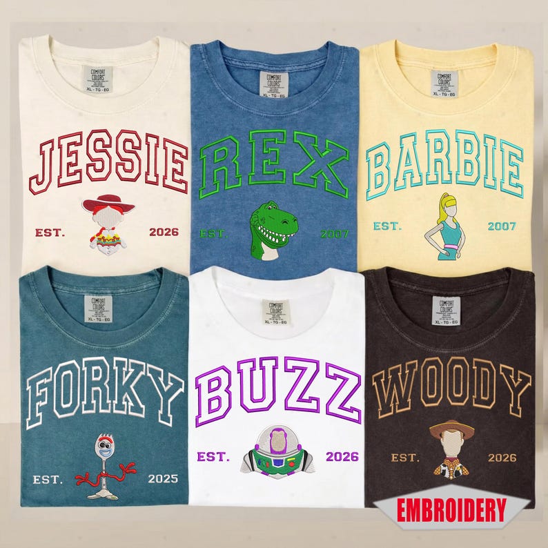 May include: Six short-sleeve t-shirts in various colors, each featuring embroidered character names and graphics. The shirts display Jessie, Rex, Barbie, Forky, Buzz, and Woody with established dates. Each shirt has a Comfort Colors brand neck label.