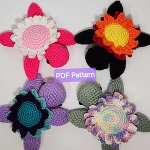 Op de afbeelding: Vijf gehaakte amigurumi-schildpad speelgoed met verschillende gekleurde schalen en bloemen. De schildpadden zijn roze, zwart, paars, groen en wit.
