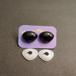 May include: Two black plastic safety eyes with a white plastic washer for each eye. The eyes are on a purple card with the text "Made in Mexico".
