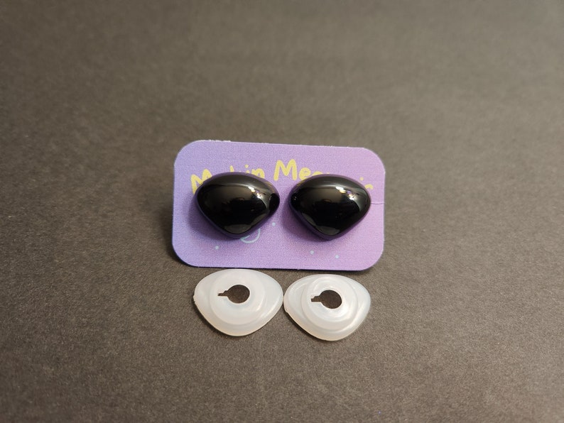 May include: Two black plastic safety eyes with a white plastic washer for each eye. The eyes are on a purple card with the text "Made in Mexico".
