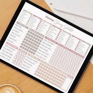 May include: A printable cleaning schedule on a tablet with a brown wooden background. The schedule is divided into daily, weekly, monthly, and annual tasks. Each task has a checkbox next to it. The schedule is designed to help people stay organized and on top of their cleaning.