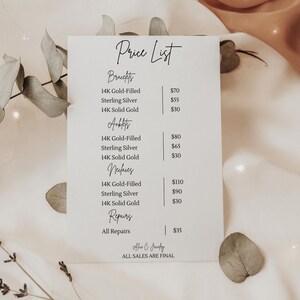 Op de afbeelding: Een prijslijst voor sieraden, met prijzen voor armbanden, enkelbandjes en kettingen in 14K goud gevuld, sterling zilver en 14K massief goud. Reparaties staan ook vermeld. De tekst is in handschrift.