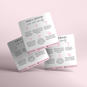 Pu&ograve; includere: Un biglietto rosa e bianco con il testo "ALICE C. JEWELRY care and warranty" e istruzioni per la cura dei gioielli. La carta include icone per la pulizia, la rimozione degli anelli a salto e la prenotazione di appuntamenti per le riparazioni. La carta include anche l'indirizzo del sito web "www.yourwebsite.com" e il numero di telefono "123-478-7115".