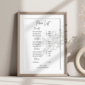 Op de afbeelding: Een ingelijste prijslijst voor sieraden, met categorie&euml;n zoals armbanden, enkelbandjes en kettingen. De lijst bevat prijzen voor 14K goudgevuld, sterling zilver en 14K massief gouden items. De tekst "Price List" staat bovenaan.