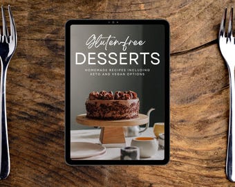 May include: A digital tablet displaying a cover image for a cookbook titled "Gluten-free Desserts: Homemade Recipes Including Keto and Vegan Options". The cover features a chocolate cake on a cake stand with a wooden base.