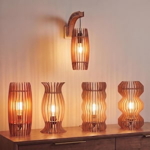 May include: A collection of wooden lamps with warm, ambient lighting. The lamps feature a natural wood finish and unique designs, including a wall-mounted sconce and various table lamp styles. The lamps are arranged on a wooden surface.