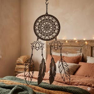 Può includere: Un acchiappasogni in legno marrone scuro con un centro circolare a motivi, dettagli di fiori di loto e pendenti a forma di piuma. L'acchiappasogni è sospeso a un gancio, mostrando uno stile bohémien. Il pezzo decorativo è progettato per essere appeso a parete.