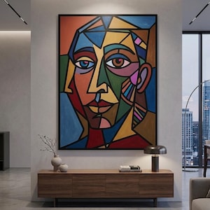 May include: A large rectangular wall art piece featuring a cubist-style portrait of a face composed of geometric shapes in vibrant colors including blue, red, yellow, green, and brown, all outlined with thick black lines on a canvas.