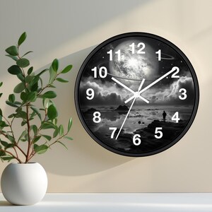 May include: Black and white clock with a moon and clouds design. The clock face has a black background with white numbers and hands. The clock is framed in a black circle.