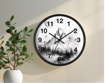 May include: Black and white wall clock with a mountain scene and a moon. The clock face has black numbers and hands.