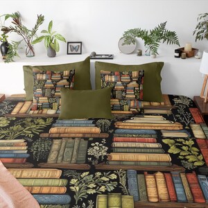 May include: A black and green bedding set with a pattern of stacked books and botanical illustrations. The bedding set includes two pillowcases and a duvet cover.