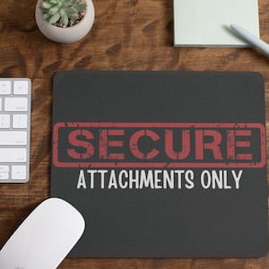 May include: A black mouse pad with the text "SECURE ATTACHMENTS ONLY" in white letters. The word "SECURE" is in a red rectangle with a distressed look.