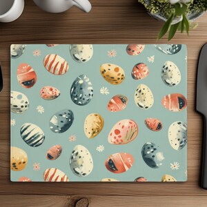 May include: A blue and white patterned placemat with a repeating design of colorful eggs. The eggs are decorated with various patterns and colors, including blue, green, red, and yellow.