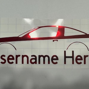 Może przedstawiać: Czerwona naklejka na samochód z napisem "Username Here". Naklejka przedstawia profil boczny samochodu, z tekstem pod obrazem samochodu. Naklejka znajduje się na białym tle z wzorem kratki.