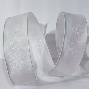 May include: A white ribbon featuring a shimmering, glittery centre panel and smooth, solid white edges. The ribbon is curled into an S-shape, displaying its reflective texture and bright, clean colour against a plain, neutral background.