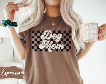 May include: A brown t-shirt with a white checkered background and the text "Dog Mom" in a retro font.
