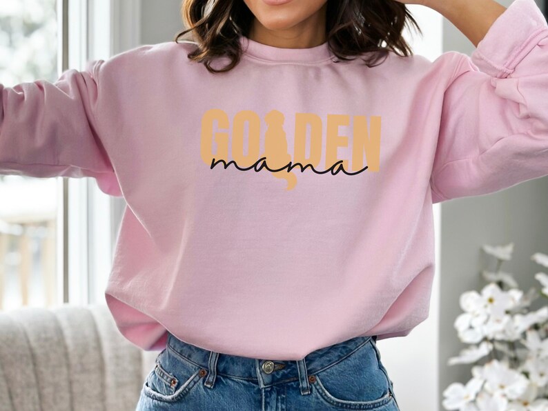 May include: A pink sweatshirt with the text "Golden mama" in a yellow-orange color.