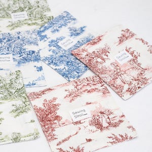 May include: Five fabric squares with a toile pattern in different colours. Each square has a white label with the text "Sewing Stroll" printed on it.