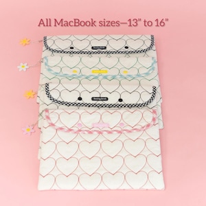 Puede incluir: Fundas para port&aacute;tiles con dise&ntilde;os de corazones en blanco y rojo, blanco y negro y blanco y azul claro. El texto "All MacBook sizes - 13" to 16"" est&aacute; en la parte superior. Las fundas est&aacute;n sobre un fondo rosa.