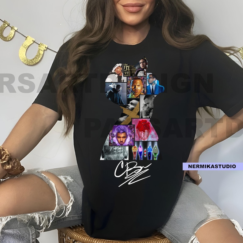 Op de afbeelding: Zwart t-shirt met een silhouetvormige collage van afbeeldingen. De collage bevat portretten en een witte handtekening. Het t-shirt heeft een ronde hals.