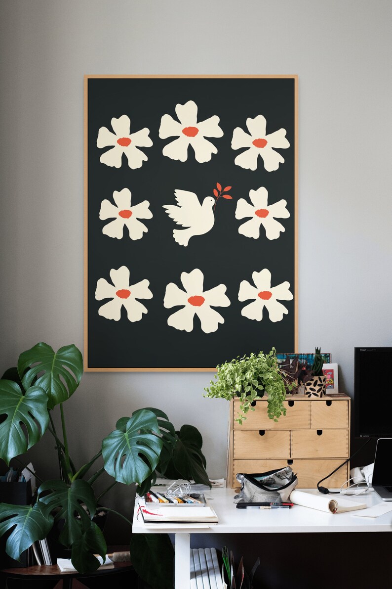 May include: A framed print with a black background and white flowers with red centers. A white dove with an olive branch in its beak flies through the center of the print.
