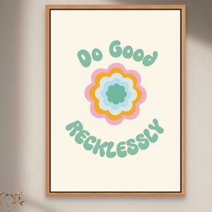 Puede incluir: Una impresión enmarcada con fondo blanco y un diseño de flor verde, azul, amarilla y rosa. El texto "Do Good Recklessly" está escrito en letras verdes.