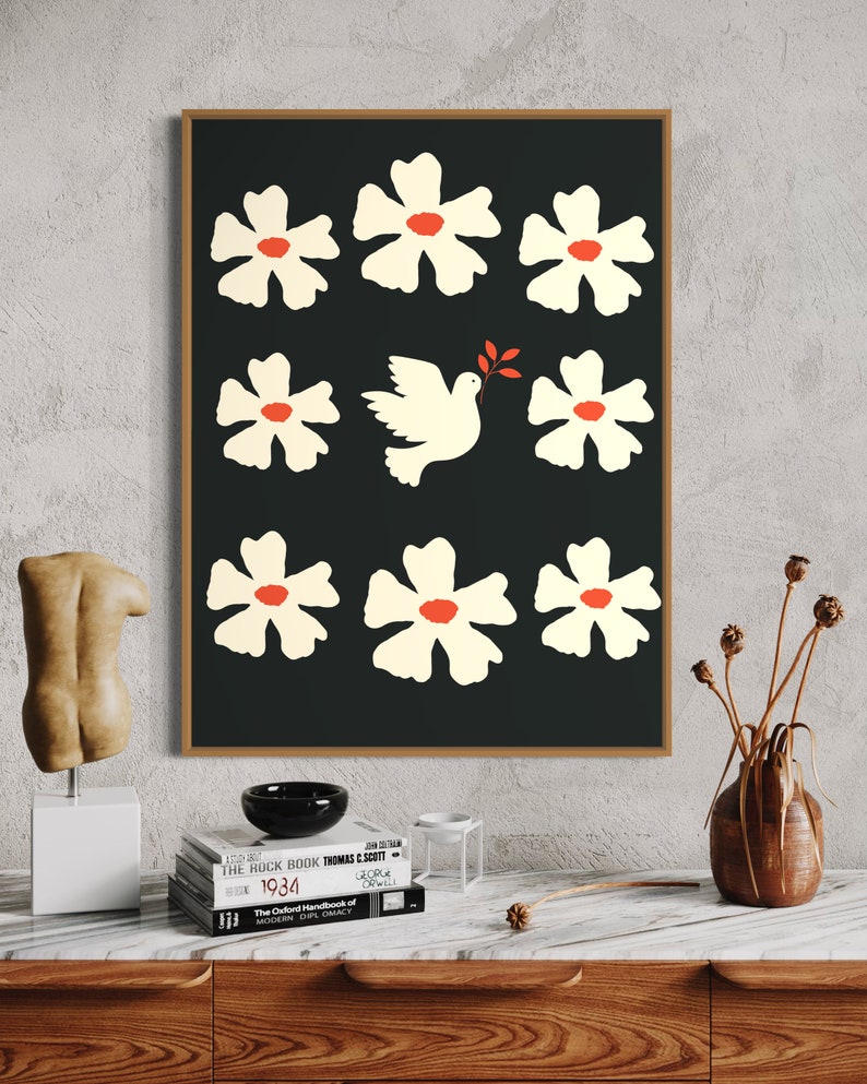 May include: A black and white print of a dove with an olive branch in its beak surrounded by white flowers with red centers on a black background.