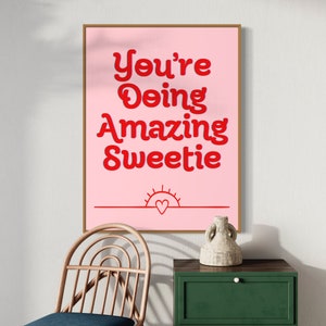 Puede incluir: Impresi&oacute;n rosa y roja con el texto "You're Doing Amazing Sweetie" con un peque&ntilde;o sol y un coraz&oacute;n en la parte inferior.