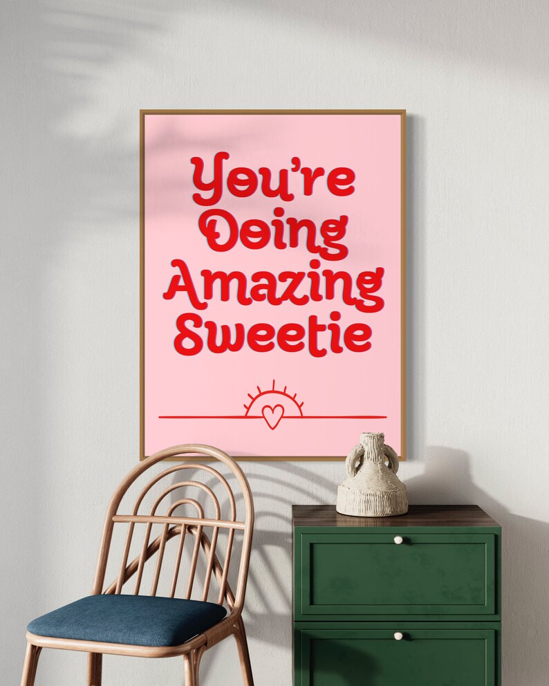 Puede incluir: Impresi&oacute;n rosa y roja con el texto "You're Doing Amazing Sweetie" con un peque&ntilde;o sol y un coraz&oacute;n en la parte inferior.