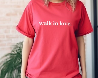 Może przedstawiać: Czerwony T-shirt z nadrukiem "walk in love." w kolorze białym na przodzie.