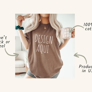 Pu&ograve; includere: Una maglietta marrone con la scritta "DESIGN AQUI" in bianco. La maglietta &egrave; realizzata in 100% cotone americano ed &egrave; prodotta negli Stati Uniti. L'immagine indica anche che il design non si crepa o si sfalda.
