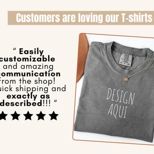 Pu&ograve; includere: Una maglietta grigia con le parole "DESIGN AQUI" stampate in bianco. La maglietta &egrave; esposta con una collana d'oro e una recensione del cliente che dice "Facilmente personalizzabile e comunicazione fantastica dal negozio!"