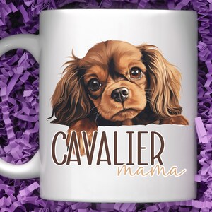 May include: White ceramic mug with a brown Cavalier King Charles Spaniel dog illustration. The text "Cavalier mama" is printed on the mug.