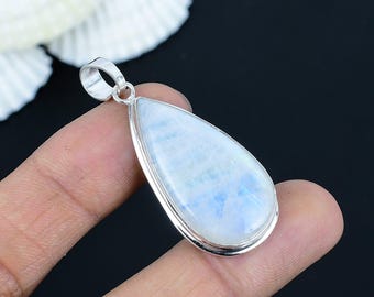 Pode incluir: Um pingente em forma de gota com uma pedra preciosa polida, azul clara e branca, emoldurada em uma moldura de prata. O pingente tem uma argola de prata na parte superior para uma corrente. A pedra preciosa tem uma aparência nebulosa.