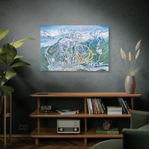 May include: A colorful ski resort map with a detailed layout of the slopes and trails. The map is framed and hanging on a wall above a wooden shelf with books and a vintage radio.