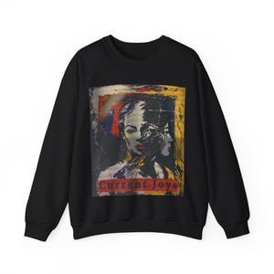 May include: Black sweatshirt with a colorful graphic print of two faces and the text "Current Joys" in red.